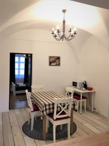 una sala da pranzo con tavolo, sedie e lampadario pendente di White Wolf Apartment a Braşov