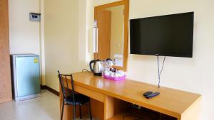 a wooden desk with a television on a wall at Sangthong Building in Mae Chaem