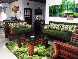 sala de estar con sofás verdes y mesa de centro en Windy Garden en Galle