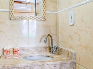 a bathroom with a sink and a mirror at Hotel Macuco in Sao Paulo