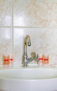 a bathroom sink with a faucet and three candles at Hotel Macuco in Sao Paulo