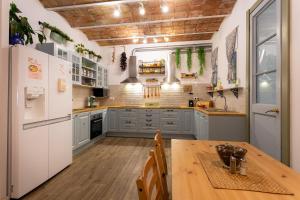 a kitchen with a wooden table and a white refrigerator at Primavera Hostel in Barcelona
