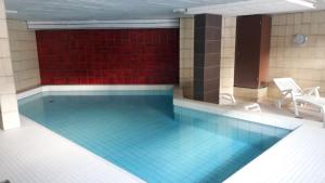 a swimming pool with a blue tile floor and a red wall at Parsennblick in Davos
