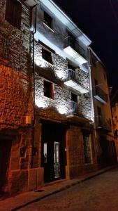 un edificio de ladrillo con balcones en una calle por la noche en Casa rural Villanueva, en Mora de Rubielos