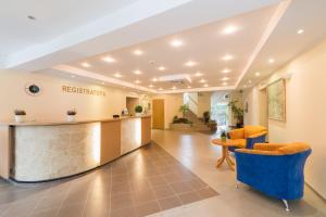 a hospital lobby with a reception counter and chairs at Hotel Vita in Druskininkai