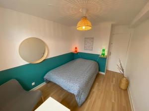 1 dormitorio con cama y espejo en 09 CHIC & COSY GRAND APPART 4 PIÈCES 75m2 HYPERCENTRE WIFI SMART TV NETFLIX, en Saint-Étienne