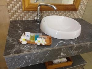 a bathroom counter with a sink and flowers on it at Zanzibar Star Resort in Nungwi