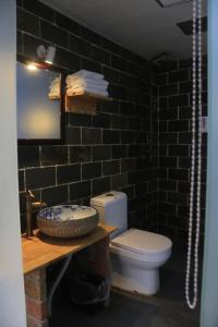 uma casa de banho com um WC e uma parede de tijolos pretos em Shu Hostel em Guiyang