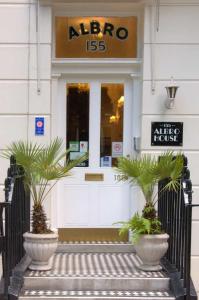 una tienda con dos grandes plantas delante de ella en Albro House Hotel en Londres
