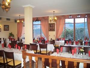 a restaurant with white tables and chairs and windows at Hostal Cerezo in Guadalupe