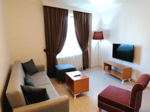 a living room with a couch and a tv at Tuzla Hill Suites in Tuzla