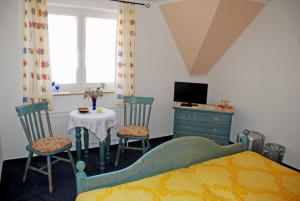 a bedroom with a bed and a table and chairs at Selliner Pension am Waldrand in Ostseebad Sellin