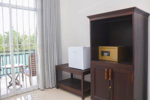 ウェリガマにあるTinara River Inn, Weligamaの電子レンジ付きのキャビネット(窓際のテーブル付)