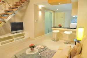 sala de estar con TV y escalera en Duplex 21 Apartment, en Bangkok