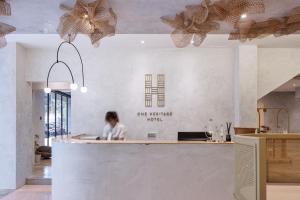 a woman sitting at a counter in a restaurant at One Heritage Hotel in Seremban