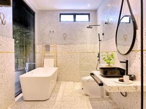 a bathroom with a tub and a toilet and a sink at One Heritage Hotel in Seremban