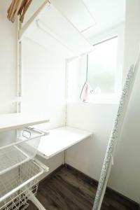 a laundry room with white shelves and a window at Periva Apartment Zagreb in Zagreb