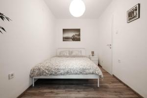 a white bedroom with a bed in a room at Periva Apartment Zagreb in Zagreb