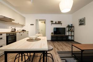 a kitchen and living room with a table and a television at Periva Apartment Zagreb in Zagreb +10 photos