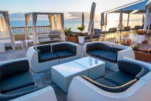 a lounge area with chairs, tables and umbrellas at Pearly Grey Ocean Club Apartments & Suites in Callao Salvaje