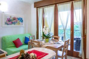 - un salon avec une table et un canapé vert dans l'établissement Apartment Fiordaliso, à Sirmione