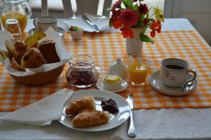 una mesa con un plato de bollería y una taza de café en Le Moulin de Lusseau, en Chef-Boutonne