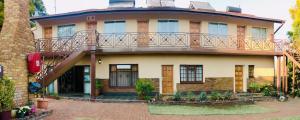 una casa con un balcón encima en Clubview Guest House, en Centurion