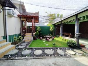 a small garden in front of a house at Jati Classic Homestay in Banyuwangi +9 photos