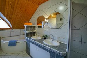 a bathroom with two sinks and a toilet and a mirror at Penzion Fantazia in Poprad
