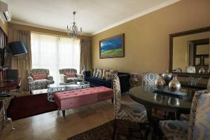 sala de estar con sofá, mesa y sillas en Mavuta Boutique Apartments, en Polokwane