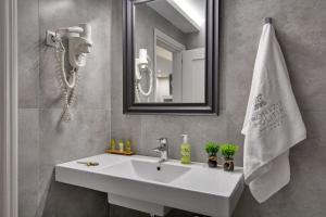 een badkamer met een witte wastafel en een spiegel bij Frontzu Politia in Ioannina