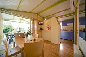 a room with a kitchen and a table with a laptop at Camping Piper in Puntone di Scarlino
