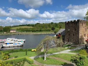 une rivière avec des bateaux amarrés à côté d'un château dans l'établissement MARA RIVIERE La Jaille Yvon, à La Jaille-Yvon