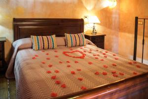 a bedroom with a bed with red roses on it at Casa Las Riquelas in Sauzal