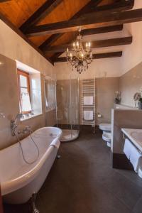 ein Badezimmer mit zwei Waschbecken, einer Badewanne und einem Kronleuchter in der Unterkunft Villa Vallis in Bribir