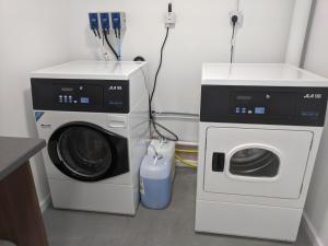a laundry room with a washing machine and a washer at Apartrooms Aberdeen in Aberdeen