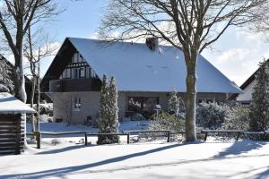 ein Haus im Schnee mit einem Zaun in der Unterkunft Ferienwohnung (H)Auszeit Pape in Winterberg