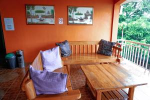 weranda z drewnianym stołem i 2 krzesłami w obiekcie La Solana Suites and Resorts by Cocotel w mieście Puerto Galera