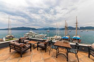 ein Balkon mit Tischen und Stühlen und Boote im Wasser in der Unterkunft Sunset Hotel Marmaris in Marmaris