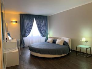 a bedroom with a large bed with a window at B&B Al Picchio in Monopoli