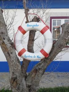 a life preserver on a tree in front of a building at Chalet O Amorzinho Sintra Praia in Sintra