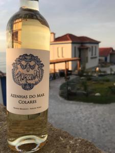 a bottle of wine sitting on top of a wall at Chalet O Amorzinho Sintra Praia in Sintra