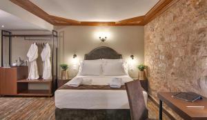 um quarto de hotel com uma cama, uma mesa e uma secretária em Frontzu Politia em Ioannina