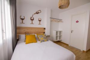 um quarto com uma grande cama branca com almofadas amarelas em Tinto Dreams Hostel em Haro