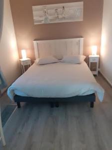 1 dormitorio con 1 cama blanca y 2 mesitas de noche en Gadeyne Nathalie Le chalet de Malvoue, en Vimoutiers