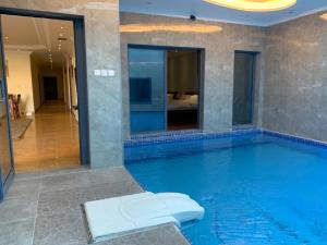 a large swimming pool in a hotel with a mirror at منتجع اليال Alyal Resort in Al Khīrān
