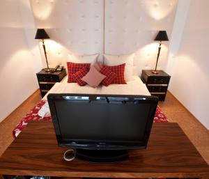 TV en una mesa en un dormitorio con cama en Hotel Rheinpark Rees en Rees