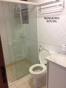a bathroom with a toilet and a glass shower at apartamento 4 praças in Torres