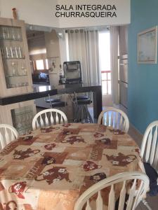 a kitchen with a table and chairs with a table and a table and a kitchen at apartamento 4 praças in Torres