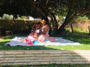 a couple sitting on a blanket on the grass at Riverton Manor in Centurion